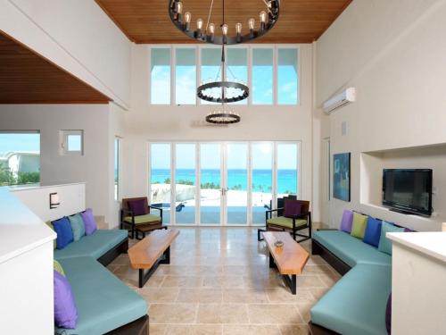 总督港Sky Beach Club Villa Waterfall 2 home的客厅设有蓝色沙发,享有海景
