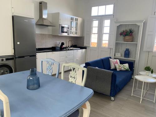 阿古洛Meriga的厨房以及带蓝色桌椅的起居室。