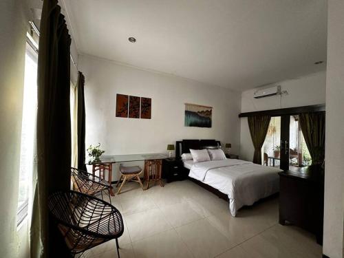 井里汶Roemah Uli Cirebon的一间卧室配有一张床和一张书桌