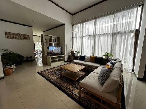 井里汶Roemah Uli Cirebon的带沙发和大窗户的客厅