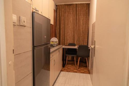 Apartman TWO的厨房配有冰箱和餐桌,设有用餐室