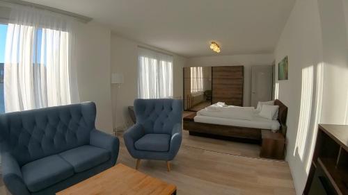因特拉肯Henry's Apartments Interlaken的客厅配有蓝色椅子和一张床
