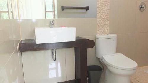 吉利特拉旺安WHITE SANDS RESORT的浴室配有白色卫生间和盥洗盆。