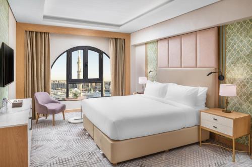 麦地那Taiba Suites Madinah的酒店客房设有一张大床和一张书桌。