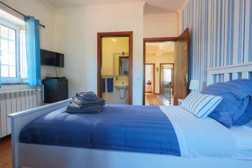 MouronhoQuinta do Rio Alva and Glamping Lodges的一间带蓝色床的卧室和一间浴室