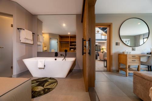 兰斯堡Bakubung Villas的一间带大浴缸的浴室和一间客厅