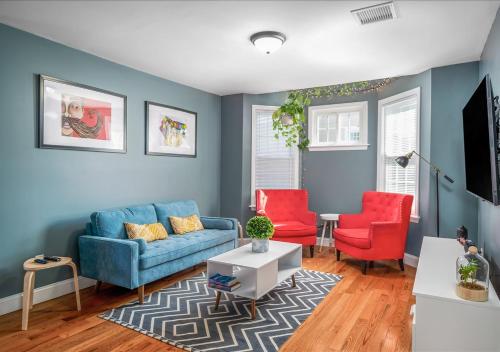 Mount VernonColorful, Comfy & Modern - Close to NYC - Parking!的客厅配有蓝色的沙发和2把红色的椅子