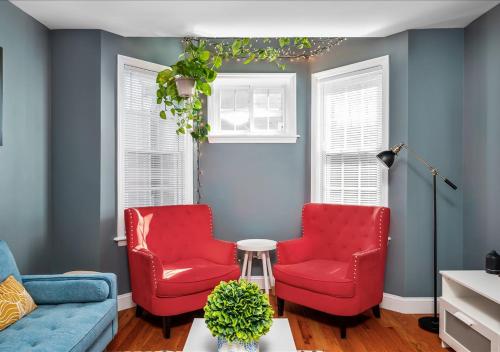 Mount VernonColorful, Comfy & Modern - Close to NYC - Parking!的客厅设有两把红色椅子和蓝色的墙壁