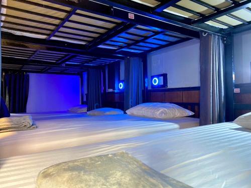 皮皮岛LONGDOO Hostel的一间卧室配有两张带蓝光灯的床