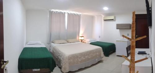 若昂佩索阿Pousada Espaco Luz do Sol Beira-Mar的一间小卧室,配有两张床和窗户