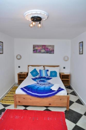 丹吉尔Dar Rif Kebdani的一间卧室配有一张床和红色地毯