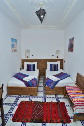 丹吉尔Dar Rif Kebdani的一间设有两张床和两把椅子的房间