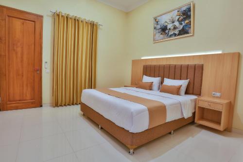 巴芝丹The Horizontal Hotel Pacitan的一间卧室配有一张大床和木制床头板