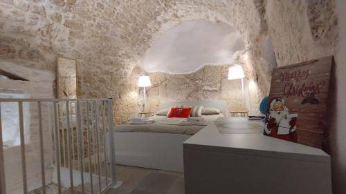 奥斯图尼Cà Giò的一间卧室设有一张床和石墙