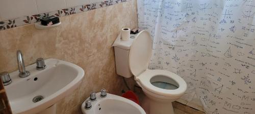 圣胡利安港ALOJAMIENTOS BJ的浴室设有卫生间和水槽,墙上写有文字。