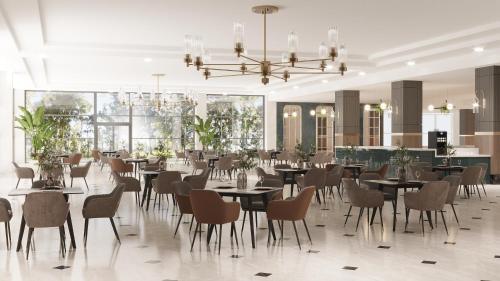 凯麦尔Dobedan World Palace Hotel ''Ex Brand Alva Donna World Palace ''的一间带桌椅和吊灯的用餐室
