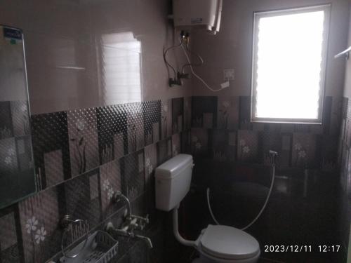 钦奈Royale Seaward Cozy Suite的一间带卫生间和窗户的浴室
