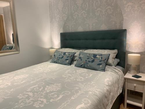 温德米尔The Lady of the Lake Windermere的一间卧室配有一张带蓝色床头板和镜子的床