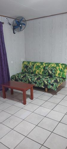 波拉波拉Raihei Location maison d'hôtes的一张绿色沙发,位于一个咖啡桌的房间