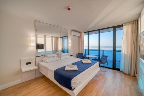 巴统Orbi City Hotel Lux View的一间卧室设有一张大床,享有海景