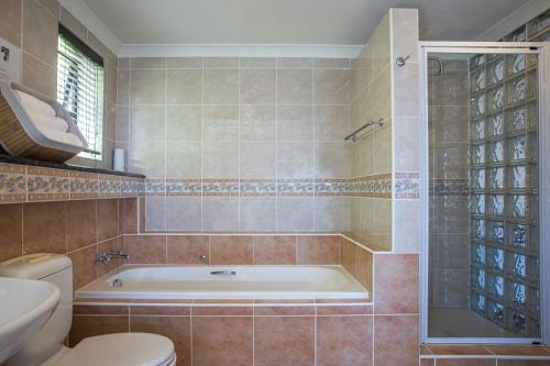 开普敦Suikerbos Guesthouse的带浴缸和卫生间的浴室。