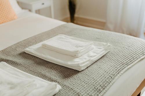 里斯本Belém Tejo - Jardim的床上有两条白色毛巾