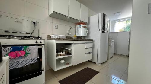 伊列乌斯Apt. em Praia do Sul de Ilhéus的白色的厨房配有炉灶和冰箱。