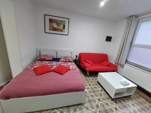 沙勒罗瓦Maison LYDIE - Meublé de vacances 3 étoiles的一间卧室配有红色的床和红色椅子