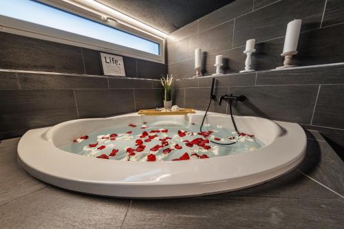 DierikonVisionary Hospitality - Big Premium Loft with View, Washer, Parking, Kitchen, Tub的一间满是心脏的浴缸的浴室