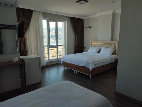 HasankeyifHasankeyf Hasbahçe Otel的一间卧室设有两张床和大窗户