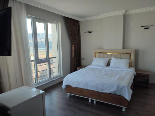HasankeyifHasankeyf Hasbahçe Otel的一间卧室设有一张床和一个大窗户