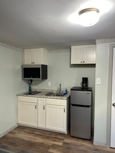 Marmora大道汽车旅馆的厨房配有白色橱柜、水槽和冰箱。