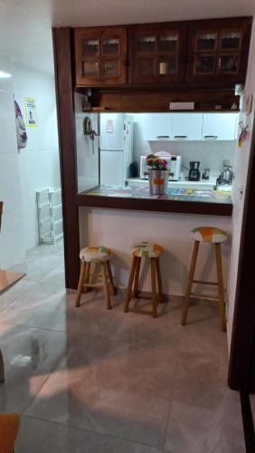 加罗帕巴Casa de 3 Quartos em Garopaba - Bairro Ferraz的厨房配有柜台和2把凳子