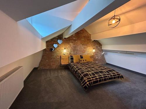 霍姆弗斯Cottage in Holmfirth Centre的一间卧室设有一张床和砖墙