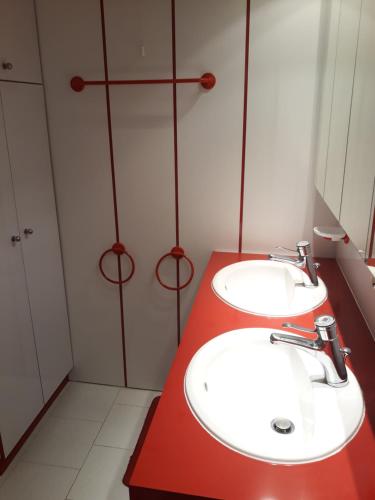 伊索拉2000Balcon plein Sud sur les pistes的浴室设有两个盥洗盆和红色的柜台。