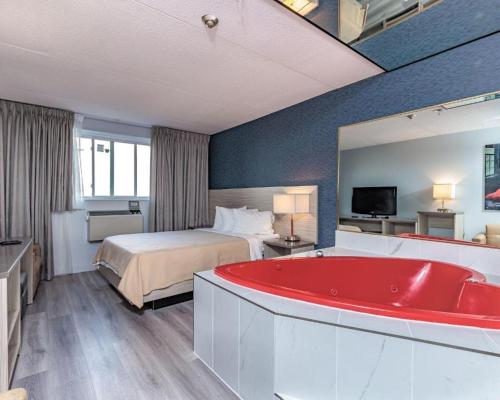 尼亚加拉瀑布Mamma's Inn的酒店客房,设有床铺和红色浴缸