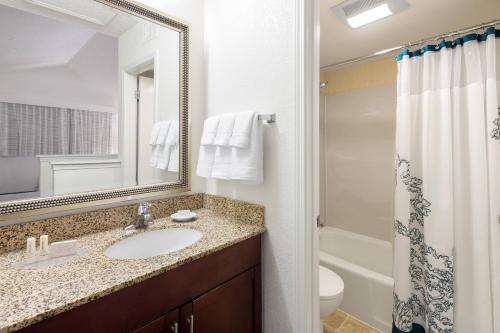 普拉森普拉森/富勒顿住宿酒店的一间带水槽、卫生间和镜子的浴室