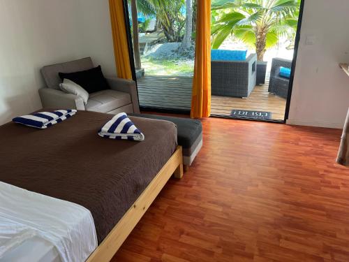 阿瓦托鲁Te Mao的一间卧室配有一张床和一把椅子,还有一个庭院