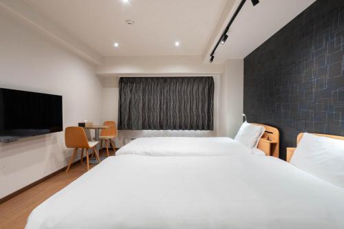 汤泽町Angel Resort Yuzawa的酒店客房设有两张床和一台平面电视。