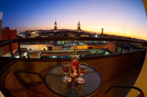 阿雷基帕ARIQUEPAY HOTEL的阳台上的桌子和两杯葡萄酒