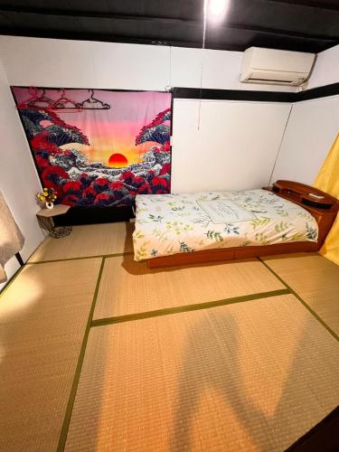 东京SnowHouse的一间设有一张床的客房,墙上挂着一幅画