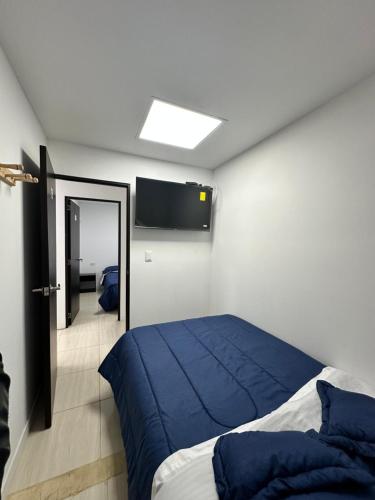 波哥大Hotel Bus Plus+的一间卧室配有一张床和一台平面电视