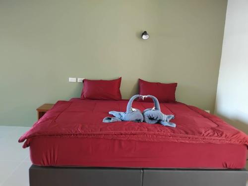 蔻立Spy home的红色的床,上面有两条毛巾天鹅