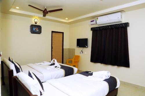 斯里卡拉哈斯蒂Hotel Elite Inn的酒店客房配有两张床和吊扇。