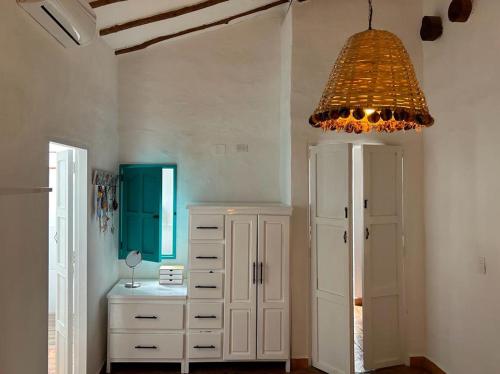 巴里查拉Casa Castañeto Barichara的一间设有白色橱柜和吊灯的房间