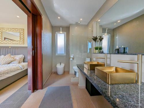 象岛马尼普拉别墅的一间带水槽的浴室和一张位于客房内的床