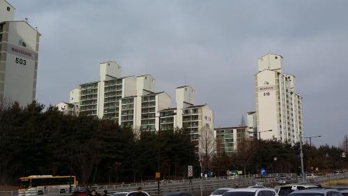 高阳市Goyang City Ilsan Apartment的停车场,高楼前有车