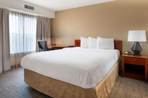 罗杰斯罗吉斯万豪原住客栈的酒店客房设有一张大床和一张书桌。