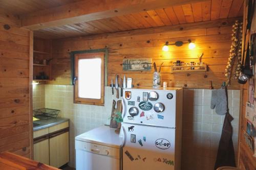科帕奥尼克Cozy chalet Montana的厨房配有白色冰箱和木墙