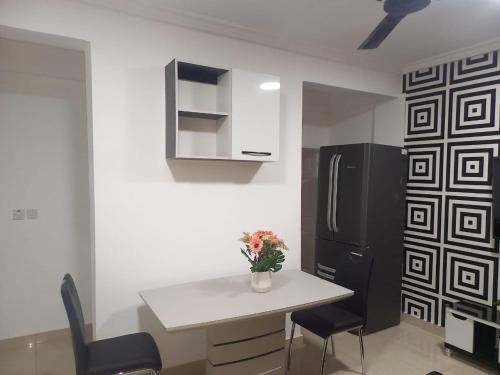 阿克拉KESEWAA's APARTMENT的厨房配有白色桌子和黑色冰箱。
